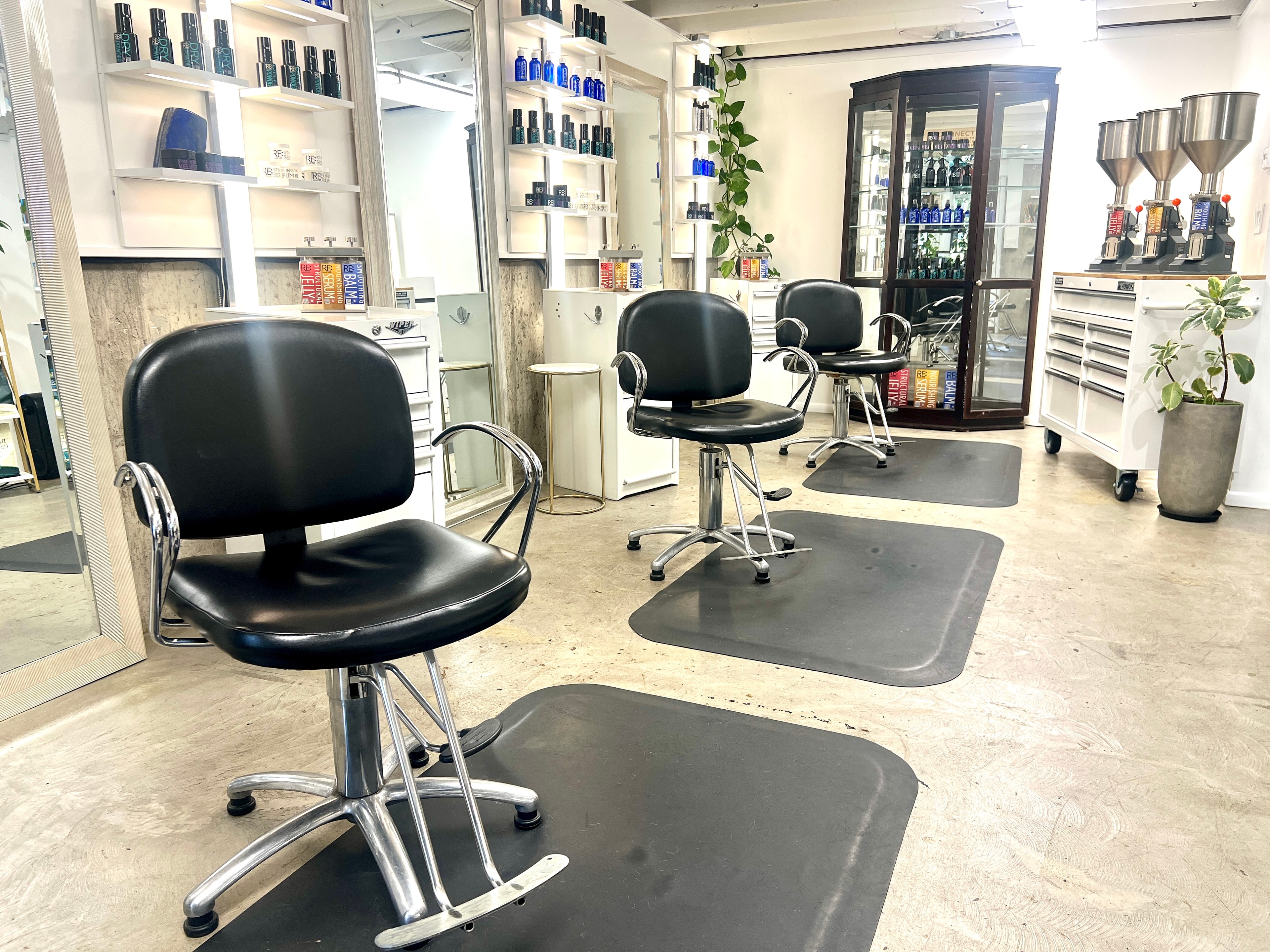The private salon studio at Tyson Daniel Hairdressing — styling chairs, mirrors and RE: haircare shelves